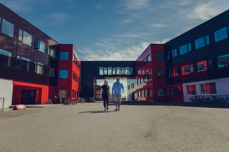 To ansatte ved Nova Sea går fremfor lokalene på Lovund